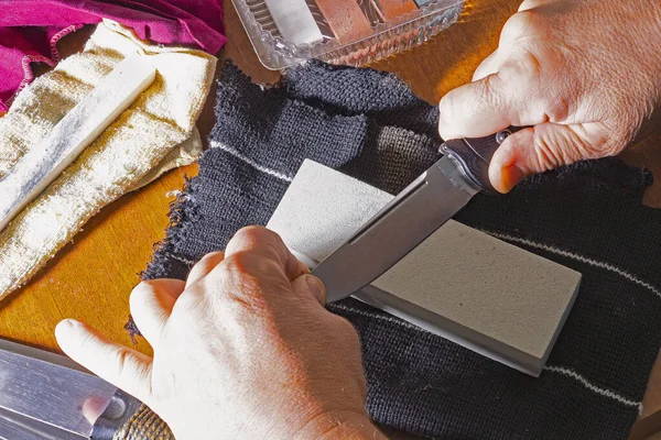 Sharpening of knives, with a sharpening stone, manually