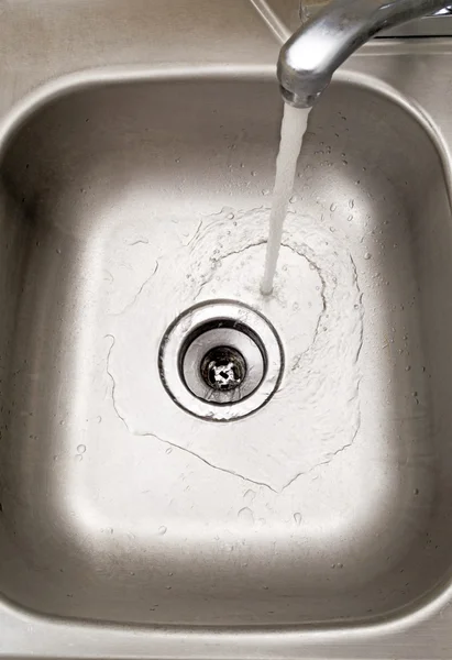 Вода течет в раковине — стоковое фото