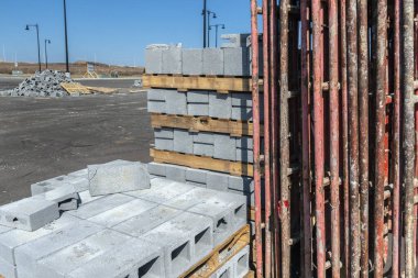 Yeni bir inşaat alanındaki yeni beton blokların ve iskelelerin yatay görüntüsü.