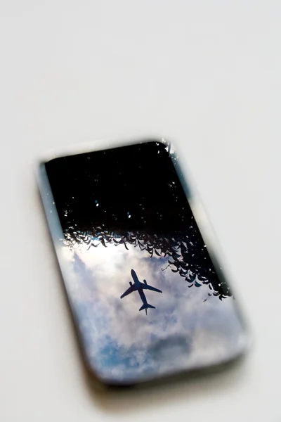 Самолет на мобильном телефоне — стоковое фото