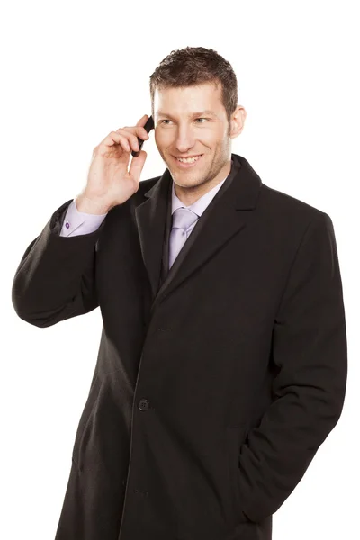 Homme souriant dans un téléphone manteau — Photo