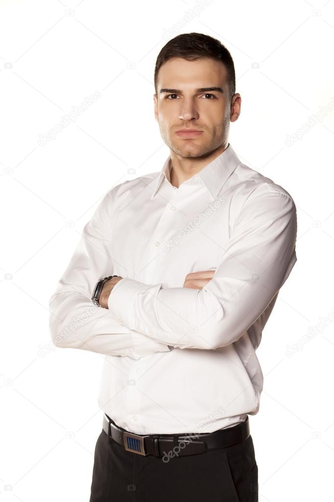 hands crossedSerious young and attractive businessman in white shirt with his hands crossed on his chest, posing on a white background