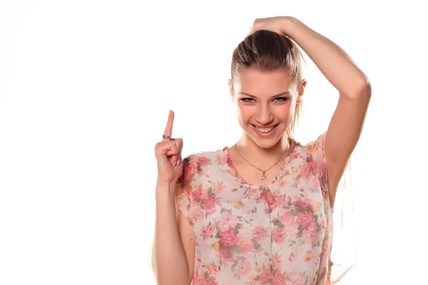 Menina apontando um dedo para um branco — Fotografia de Stock