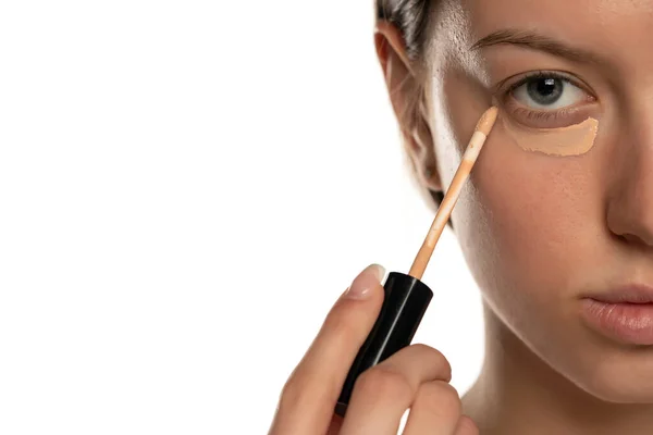 Närbild Ung Kvinna Med Blå Ögon Tillämpa Concealer Ögat Vit — Stockfoto