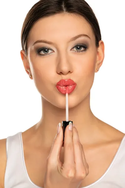 Zdjęcie Głowy Kobiety Nakładającej Błyszczyk Usta Gestem Całowania Białym Tle — Zdjęcie stockowe