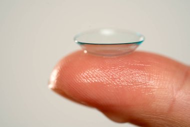 Parmağındaki kontakt lensin makro görüntüsü.