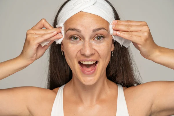 Wanita Muda Yang Bahagia Dengan Ikat Kepala Membersihkan Wajahnya Dengan — Stok Foto