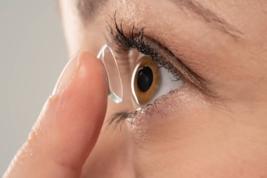 Kontakt lens takan genç bir kadının yakın plan fotoğrafı. Yan görünüm.