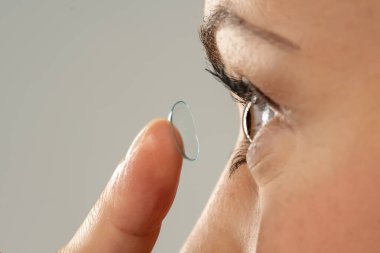 Kontakt lens takan genç bir kadının yakın plan fotoğrafı. Yan görünüm.
