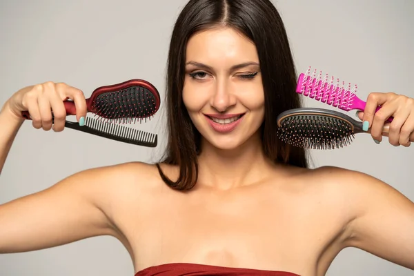 Uzun Saçlı Göz Kırpan Genç Bir Kadın Saç Fırçasıyla Poz — Stok fotoğraf
