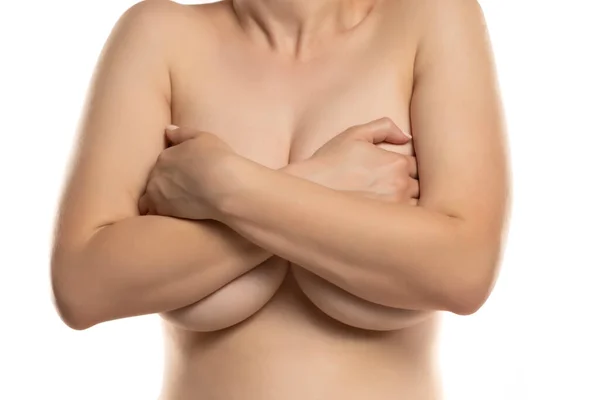 Kvinnan Täcker Med Båda Händerna Sina Stora Bröst Vit Bakgrund — Stockfoto