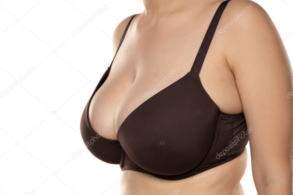 A woman with large breasts in a bra to a white background