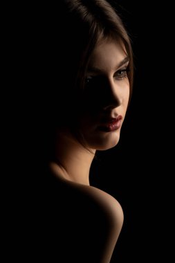 Siyah bir arka planda genç ve güzel bir kadının şehvetli portresi.