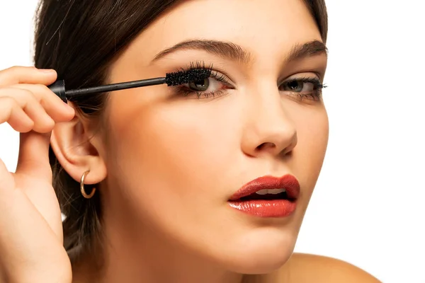 Una Giovane Bella Donna Applica Mascara Uno Sfondo Bianco — Foto Stock