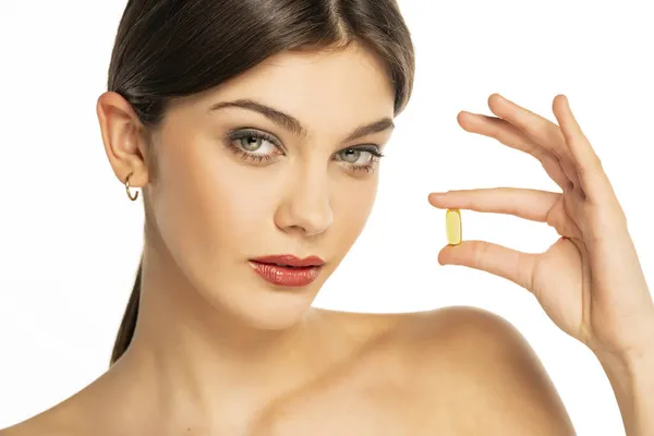 Una Bella Giovane Donna Che Tiene Una Pillola Vitaminica Tra — Foto Stock