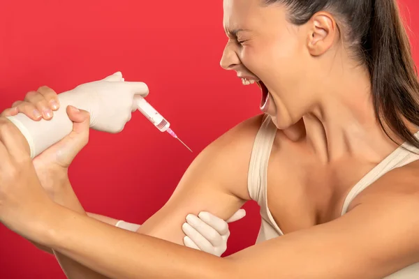 Uma Jovem Mulher Gritando Recusa Ser Vacinada Fundo Vermelho — Fotografia de Stock