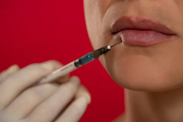 Close Uma Jovem Mulher Procedimento Injeção Preenchimento Facial Fundo Vermelho — Fotografia de Stock