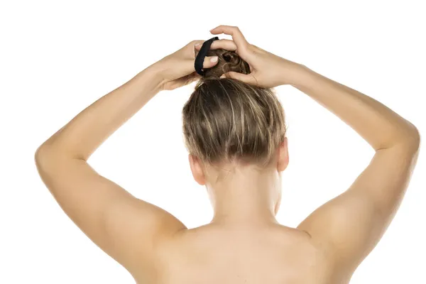 Visão Traseira Uma Jovem Loira Amarrando Seu Cabelo Fundo Branco — Fotografia de Stock