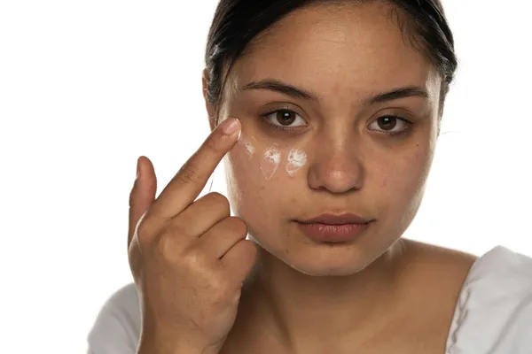 Una Mujer Joven Aplica Crema Facial Bajo Sus Ojos Sobre — Foto de Stock