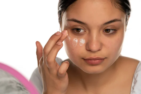 Una Joven Hermosa Mujer Aplica Crema Facial Sobre Fondo Blanco —  Fotos de Stock