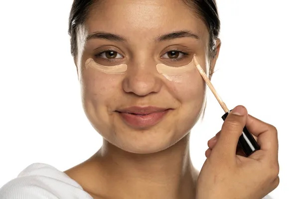 Closeup Young Beautifu Smilingl Woman Applies Concealer Her Eye White — Stok Foto