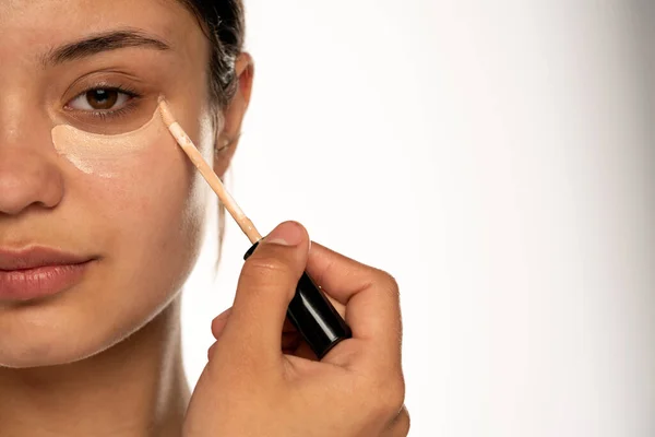 Closeup Young Beautiful Woman Applies Concealer Her Eye White Background — Stock Photo, Image