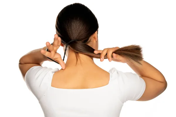 Rückseite Frau Strafft Ihre Haare Mit Einem Gummiband Auf Weißem — Stockfoto