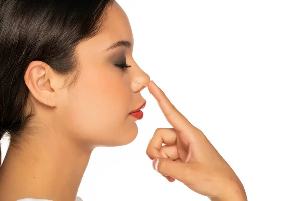 Profil Seorang Wanita Muda Menyentuh Hidungnya Pada Latar Belakang Putih — Stok Foto