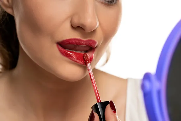 Een Vrouw Brengt Rode Lip Gloss Haar Lippen Een Witte — Stockfoto