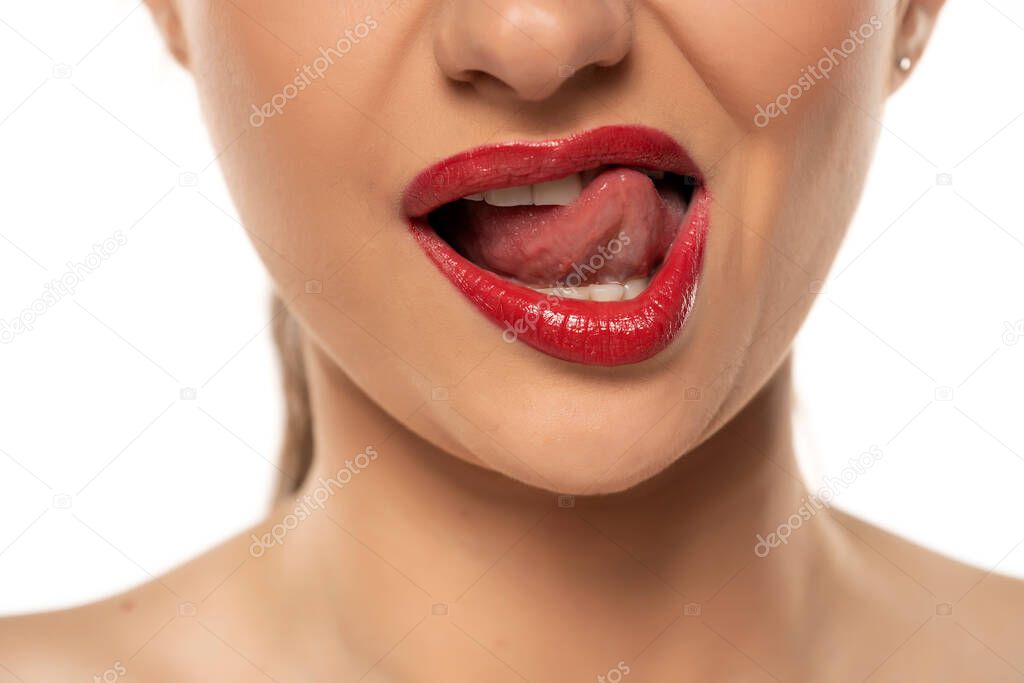 Close up of a woman toushing the lips with her tongue on a white background