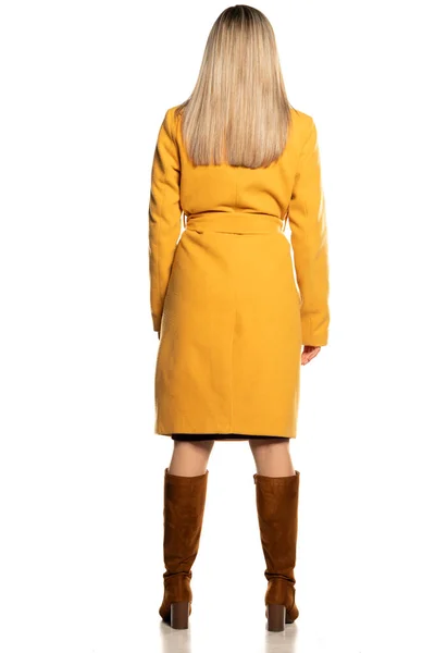 Rückansicht Einer Blondine Gelbem Mantel Und Lederstiefeln Auf Weißem Hintergrund — Stockfoto