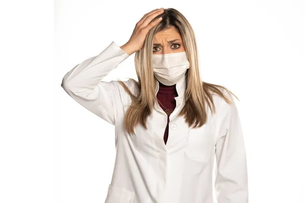 Junge Schockierte Ärztin Mit Gesichtsmaske Auf Weißem Hintergrund — Stockfoto