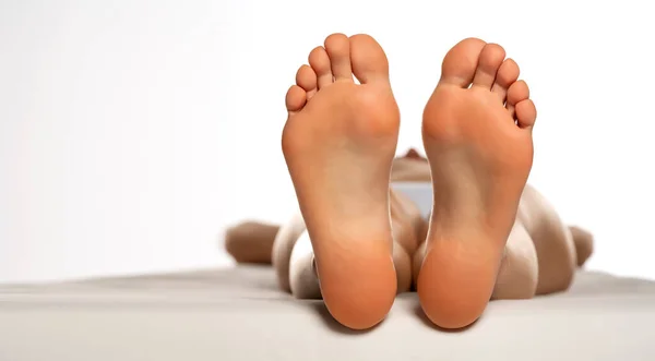 female soles on a white bed and white background