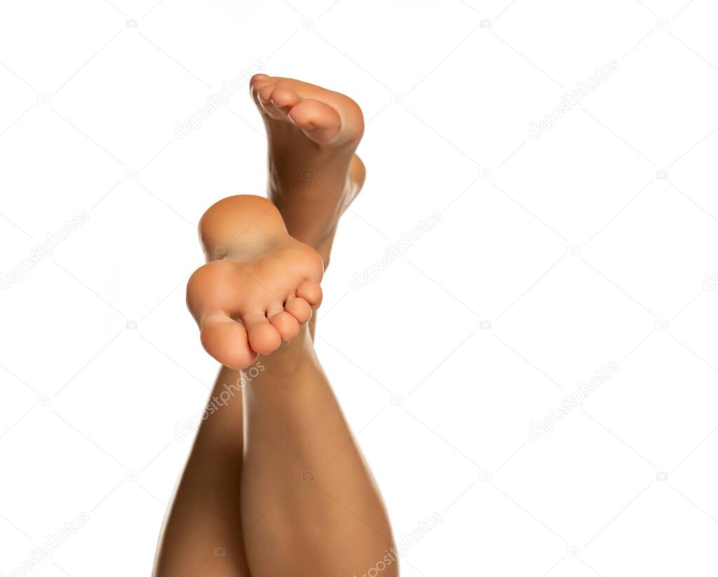 female crossed bare feet on a white background