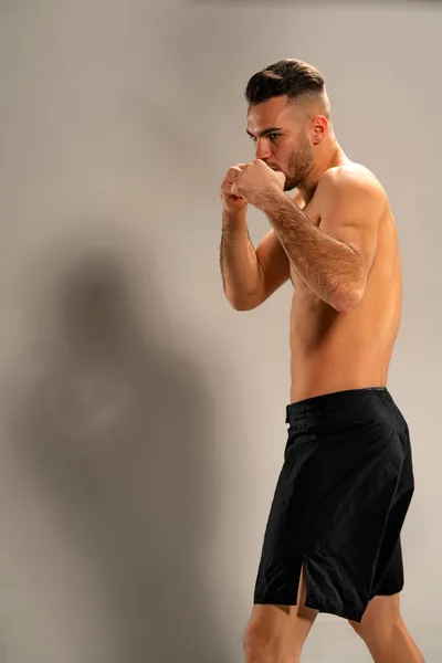 Mma Vechter Zwarte Shorts Een Vechtpositie Een Grijze Achtergrond — Stockfoto