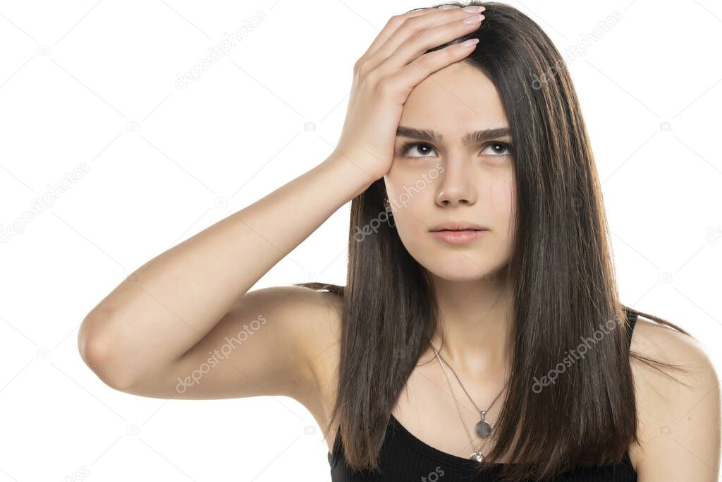 portrait of a beautiful teenage girl looking up and holding her head against a white background