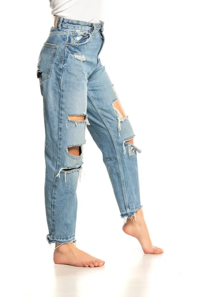 Pernas Uma Mulher Jeans Rasgado Fundo Branco — Fotografia de Stock