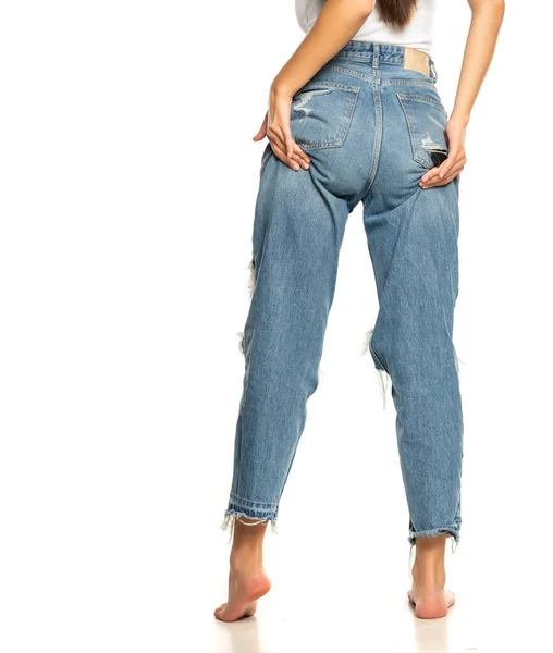 Kvinnan Jeans Reser Sina Skinkor Med Händerna Vit Bakgrund — Stockfoto