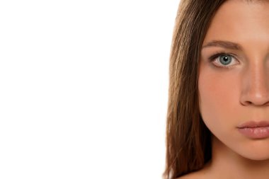 Beyaz arka planda genç, ciddi ve güzel bir kadının portresinin yarısı.