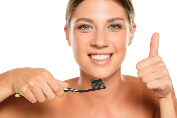 Happy Young Woman Holding Toothbrush Black Charcoal Paste White Background — Stock Photo, Image