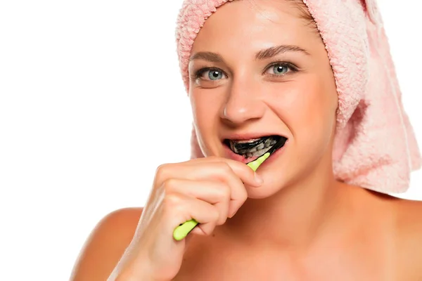 Junge Glückliche Frau Beim Zähneputzen Mit Schwarzer Kohlepaste Auf Weißem — Stockfoto