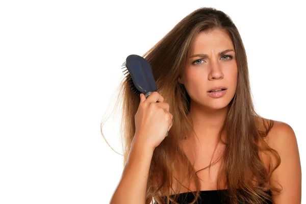 Giovane Donna Nervosa Brusing Capelli Con Spazzola Capelli Sfondo Bianco — Foto Stock