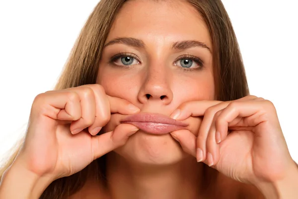 Una Joven Mujer Aprieta Sus Labios Sobre Fondo Blanco —  Fotos de Stock