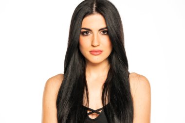 Beyaz arka planda uzun siyah saçlı ve makyajlı güzel bir genç kadın.