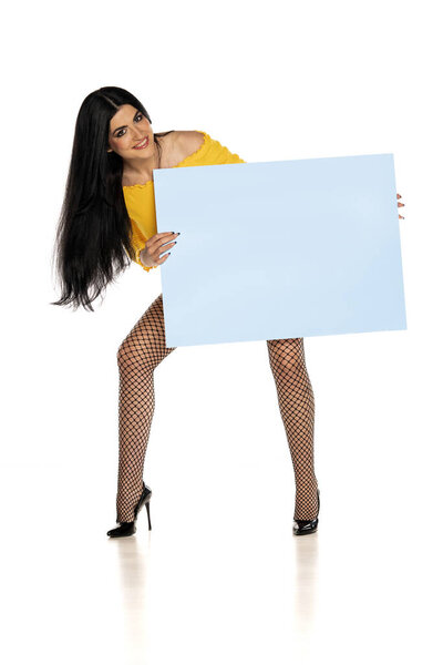 молодая женщина в рыбных сетях чулки с рекламой пустой синей доски на белом фоне