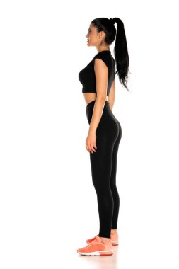 Beyaz arka planda duran güzel ve genç bir kadının yan görüntüsü.