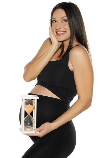 Беременная Молодая Счастливая Женщина Черных Леггинсах Рубашке Позирует Песочными Часами — стоковое фото