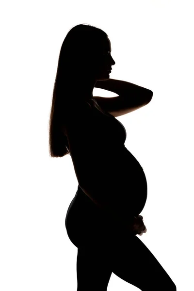 白い背景に若い妊婦のシルエットが — ストック写真