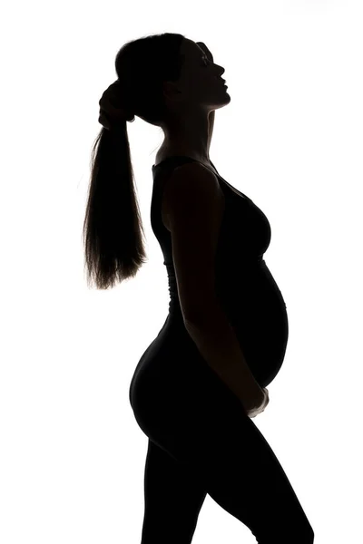 Silhouet Van Een Jonge Zwangere Vrouw Houdt Haar Paardenstaart Een — Stockfoto