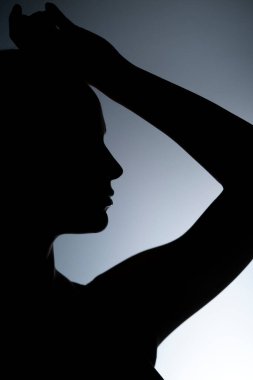 Gri arka planda güzel bir kadının silueti.